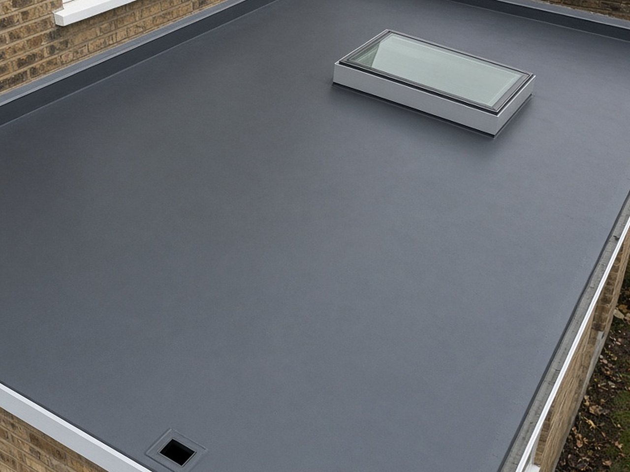 New flat roof with a grey rubber membrane, upstands and a rooflight